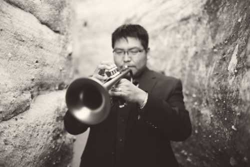 A black and white photo of a man playing trumpet